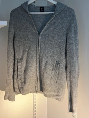 Cashmere hoodie från Boggi milano  - Mjuk och stilren grå hoodie från Boggi Milano i cashmere. Dragkedja framtill, två fickor och ribbade muddar. Perfekt för en chill och snygg look.