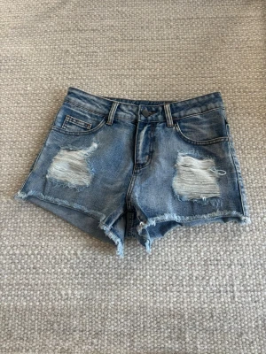 Blå jeansshorts med slitningar - Snygga blå jeansshorts med slitna detaljer och fransig kant. Mid waist!💞💞