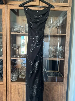 Svart paljettklänning Gina tricot - Säljer en jätte fin svart lång blommig paljett klänning. Använts en gång på nyår förra året. Derför jag säljer den då den inte kommit mer till användning. Den är i storlek M. Men knytning i ryggen så går att justera så den sitter perfekt på kroppen. Ny pris 599kr🌸