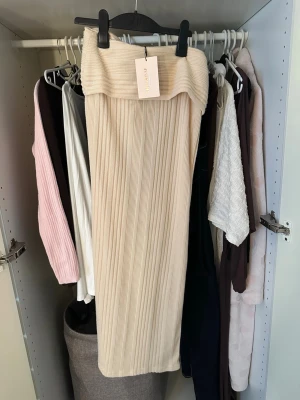 Beige ribbad långkjol från SHEIN - Trendig beige långkjol från SHEIN i ribbat material. Kjolen har en hög midja och en smickrande, rak passform som passar perfekt till både sneakers och boots. Enkel att styla med olika toppar för en cool och avslappnad look.