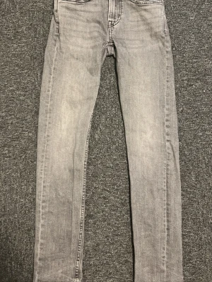 Grå jeans 28/32 - Snygga grå jeans. Jeansen har en tvättad look och raka ben. Perfekta för en avslappnad och trendig stil.
