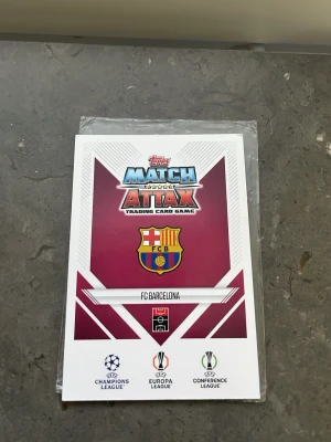 Match Attax FC Barcelona Messi kort - Unikt Match Attax samlarkort från Topps med FC Barcelona och Lionel Messi. Kortet har färgstark vintage design, holografiska detaljer och klubbens logga. Perfekt för dig som gillar fotboll och samlar på sportkort.
