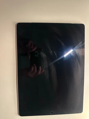 Apple iPad Pro 12,9 tum 16.7.11  - Säljer en Apple iPad med stor svart touchskärm och silverfärgad baksida med Apple-logga. Platt och tunn design, rundade hörn och hemknapp på framsidan. Perfekt för surf, spel och streaming. Funkar Helt och hållet med inga skador alls och batteri hälsan på 94%. Den funkar även med Apple penna men har tyvär ingen.