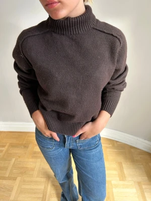 Mörkbrun stickad polotröja💖💖🌸 - Mysig mörkbrun stickad tröja med hög polokrage och ribbade muddar vid ärmslut och nederkant. Tröjan har en avslappnad passform och är perfekt för kyligare dagar. Materialet ser ut att vara mjukt och värmande, troligen ull eller ullmix.