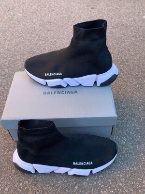 Balenciaga Speed Trainer sneakers svart - Säljer ett par svarta Balenciaga Speed Trainer sneakers med vit chunky sula och stickad ovandel. Skorna har en strumpliknande passform och Balenciaga-logga på sidan. Materialet är stretchig textil och sulan är i gummi för extra komfort.