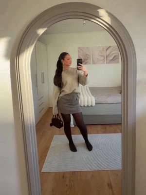 Kjol Gina Tricot XS - Stilren beige kortkjol i ullmix med två fickdetaljer framtill och diskret dragkedja. Kjolen har en rak passform och passar perfekt till stickade tröjor eller blusar. Enkel att matcha och ger en snygg, clean look.