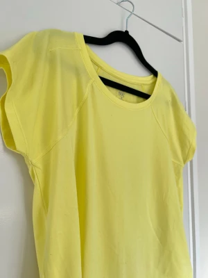 Gul träningst-shirt från SOC, storlek XS - Fräsch gul t-shirt från SOC (Stadium). Enkel och stilren  och supersöt för träning nu i vår/sommar. Lite oversized och lös i passformen, superskön!