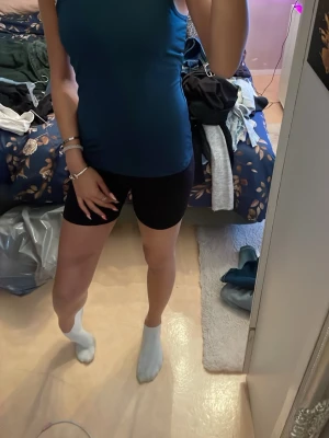 Mörk blått sportlinne - Mörkblått tajt tränings linne.De har en enkel och sportig design som sitter bekvämt och följer kroppen. Perfekta för gymmet, löpning eller andra aktiviteter under sommaren.