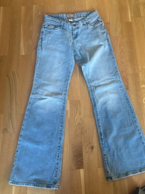Ljusblå bootcut jeans Stevi & Barry's - Snygga ljusblå jeans från Stevi & Barry's med klassisk femficksmodell och bootcut-ben. Tillverkade i denim med en skön passform och regular midja. Perfekta för en avslappnad och trendig look.