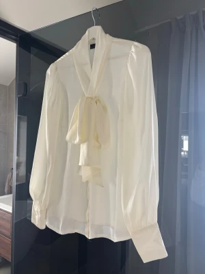 Krämvit blus med knytband Stockh LM  - Elegant krämvit blus 