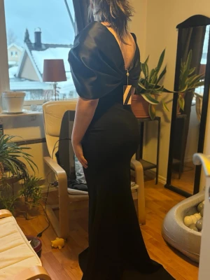 Svart balklänning  med stor rosett från bubbelroom - Elegant svart långklänning med stor rosett i ryggen. Perfekt för speciella tillfällen så som bal när du vill sticka ut. Köpt från bubbelrroom och är slutsåld på deras sida. Den är i kostym material och fin kvalitet. Endast testad 1 gång, fler bilder fås vid intresse 💞 Den som skriver snabbt och köper klänningen kan få den billigare.