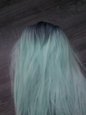 Lång pastellblå cosplayperuk - Säljer en lång och vågig peruk i pastellblå färg med mörkare rötter. Perfekt för cosplay eller maskerad, ger en cool och unik look. Peruken är syntetisk och har naturligt fall. Passar dig som vill sticka ut och testa något nytt.