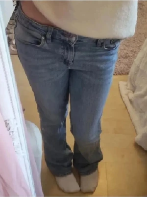 Ljusblå bootcut jeans från gina tricot - Säljer ett par ljusblå jeans från Gina Tricot med klassisk femficksdesign och bootcut-ben. Jeansen har normal passform, midwaist och är tillverkade i mjukt bomullsjeansmaterial. I använt skick, men har inga större hål eller skador. Nypris runt 150 kr. 💓