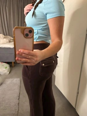 Bruna velourleggings med fickor - Säljer ett par bruna leggings i mjuk velour med dragsko i midjan och stora fickor både fram och bak. Snyggt avslappnad passform och perfekta för en chill look. Passar dig som gillar bekväma men ändå trendiga byxor.