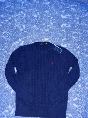 Ralph lauren sweatshirt  -  Säljer en Kabelstickad mörkblå tröja från Polo Ralph Lauren  i helt nytt skick väldigt mjukt och skönt material.Storlek s.