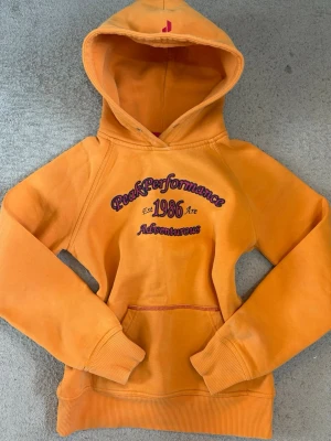 Peak Performance vintage hoodie S - Vintage orange hoodie från Peak Performance med broderat tryck framtill. Har några blekta fläckar (se sista bilderna), annars i fint skick 💕💕