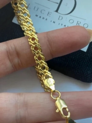 Guldlänkat halsband Luce D'Oro pläterad med stämpel 750 - Snyggt guldfärgat halsband från Luce D'Oro med italiensk design. Halsband har en bred, flätad kedja och karbinlås. Tillverkat i metall med en glansig finish som ger en exklusiv känsla. Perfekt accessoar för att lyfta din stil.stämplade 750 och italy