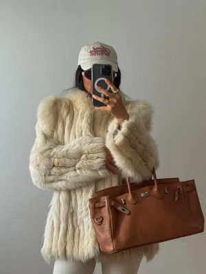 Ljus Creme Vit Päls Jacka Pälsjacka Kort Fur  - Säljer en lyxig fluffig vintage pälsjacka med rak passform och diskret krage. Passar XS. Kan skicka mått vid intresse. Fint vintage skick. En hyska är sönder dock. Men man kan lätt fixa dit en ny. 