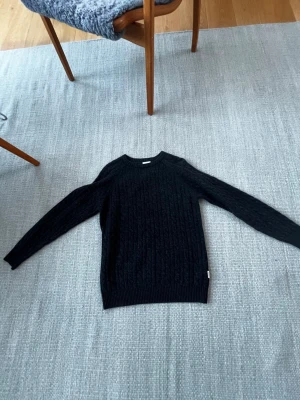 Kabelstickad tröja Lindbergh - Tröjan är använd endast 1 gång och köpt för runt 800. 100% lammull. Hör av dig vid frågor!