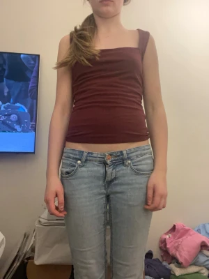 Vinröd ärmlös tubtopp - Säljer en vinröd, tight tubtopp med breda axelband. Toppen skick, storlek S och köpt från Gina 
