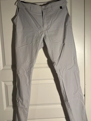 Ljusgrå chinos från Peak Performance - Säljer ett par ljusgrå chinos från Peak Performance. Byxorna har raka ben, klassisk passform och två bakfickor med diskreta ficklock. Materialet känns lätt och smidigt, perfekt för en clean och stilren look.