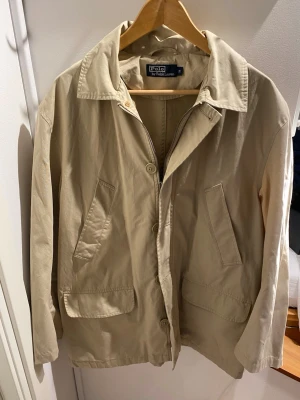 Ralph Lauren ( Jacka/Kappa ) - Polo Ralph Lauren. Beige och som ny. Extremt bra pris redan. Kommer ej gå ned mycket! Hör av dig i DM så hjälper jag dig där :)