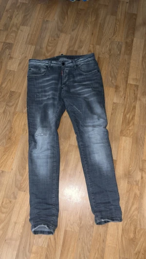 Mörkgrå slitna jeans med tvättade detaljer - Säljer DSQUARED2 jeans. Gråa storlek 46.                                              PRISET KAN SÄNKAS!!