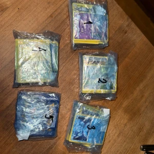Pokémonkort, 100 st för 150kr, hög 2  - Blandade Pokémon kort i färdiga högar om 100st kort för 150kr per hög. Inga specialkort utöver holo/reverse holo men bra för en nybörjare eller för barn som vill börja samla.  Därav priset..