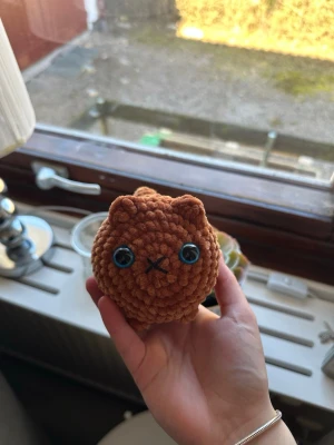 Virkad katt med fläckar - Handvirkad katt i en orange/brun färg med vita fläckar och blå ögon. Ca 13 cm lång (svans inkluderad). Katten har säkerhetsögon som inte är lämpliga för barn under 3 år💗