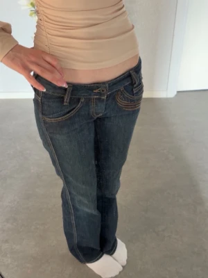 Diesel jeans  - Extremt lågmidjade jeans ifrån Diesel i modellen Ryoth. Jeansen är mörkblå med bruna broderingar. Strl W24/L30 