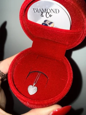 Halsband vitt guld och äkta diamanter hjärthänge Diamond & Co - Snyggt halsband från Diamond & Co med ett gnistrande hjärthänge i vitt guld och äkta diamanter. Kedjan är i silver.