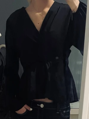 Marinblå omlottblus med lång ärm - Snygg marinblå omlottblus. Blusen har långa ärmar och har silkes material. Hade ett litet hål på baksidan men sydde ihop det, syns ej när den används.🫶🏼