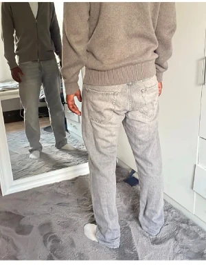 Ljusgrå raka jeans - Säljer ett par ljusgrå jeans med rak passform och klassisk femficksdesign. Jeansen har en avslappnad look och är tillverkade i denim med en tvättad finish. Perfekta för en casual stil och passar till det mesta.