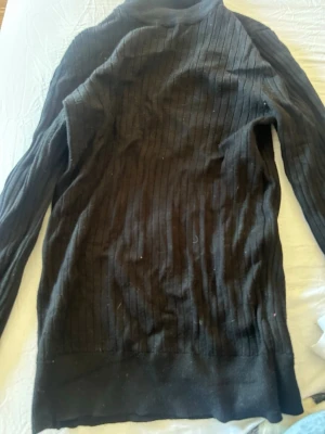 Svart polotröja från Gina Tricot - Säljer en svart ribbstickad polotröja från Gina Tricot. Tröjan har lång ärm, hög polokrage och är tillverkad i mjukt, stretchigt material. Perfekt basplagg med smal passform och diskret struktur.