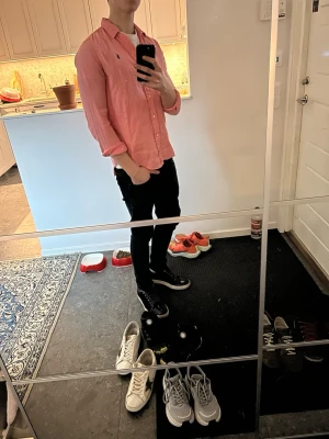 Rosa linne skjorta från Ralph Lauren - Säljer en snygg rosa skjorta från Ralph Lauren med klassisk krage och knappar framtill. Storlek xs men kan nog passa s också. Kommer va riktigt snygg nu på våren och sommaren!