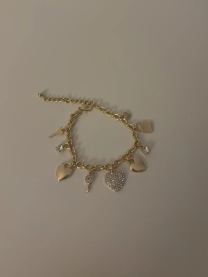 Guld armband - Jättefint guldarmband med charms som är Justerbart. Jag köpte det på emporia