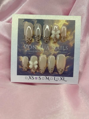 SoftLeo (S);Medium Almond - Handgjorda press-on naglar i nude med leopardmönster och 3D-rosetter. Medium Långa, mandelformade naglar med glansig finish. Perfekt för dig som vill ha en trendig och unik look.S: 15 mm, 11,5 mm, 12 mm, 11 mm, 9 mm 