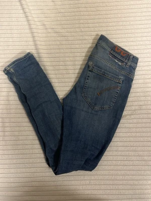 Dondup George jeans w30 - Snygga blå jeans från dondup med smal passform och klassisk femficksdesign. Jeansen har en mörk tvätt och detaljerade sömmar på bakfickorna. Ställ gärna frågor jag svarar direkt!✅ fraktar direkt✅ 