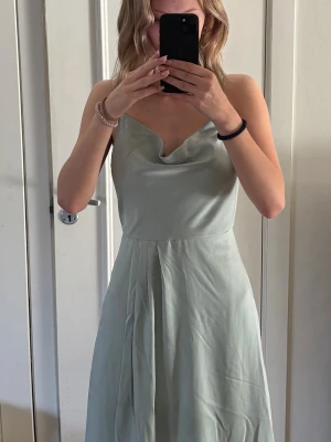 balklänning  - pastell grön balklänning från bubbelpool, både dragkedja och knappar i ryggen, tunna band och lite pösig vid brösten. jag har sytt upp den i längden då den var för lång för mig, jag är 162cm o den är lite lång utan klackar men med klackar blir det en perfekt längd. använt 1 gång så klänningen är i ett jätte bra skick