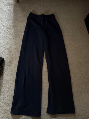 Mörkblå mjukisbyxor från Gina Tricot - Sköna mjukisbyxor, sitter till vid bena så man får en skön passform. Elastiska. 