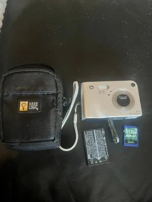 HP Photosmart R507 digitalkamera silver - Säljer en kompakt HP Photosmart R507 digitalkamera i silver med 4.1 MP och Pentax-objektiv. Kameran har optisk zoom, medföljande SD-kort på 512MB, batteri och en svart Case Logic-väska. Perfekt för dig som vill ha en enkel och smidig kamera till vardags. Laddare ingår ej !