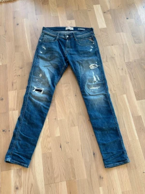 Blå slitna jeans från Replay - Säljer ett par blå jeans från Replay med skinny fit och slitningar. Knappt änvänds och sitter bra i storlek. Anbass. Skriv om ni har frågor!!! Pris ej hugget i sten.