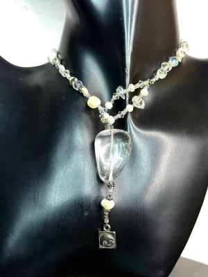 Y2K Vintage Baglady boho luxe halsband i äkta bergkristall & sötvattenspärlor – samlarfavorit - Baglady halsband i boho luxe-stil från sent 90-/tidigt 00-tal. Ett uttrycksfullt smycke från en tidigare kollektion från Baglady, ett svenskt varumärke som idag inte längre är i produktion.  Tillverkat med äkta bergkristall (klar kvarts) och sötvattenspärlor, kombinerat med detaljer som skapar djup och lyster. Asymmetrisk och ny nslekfull design med ett större hänge som tydligt blickfång.  Längd ca 44 cm, hänge ca 7,5 cm. Utmärkt vintageskick.  Priset är redan lågt så jag prutar inte