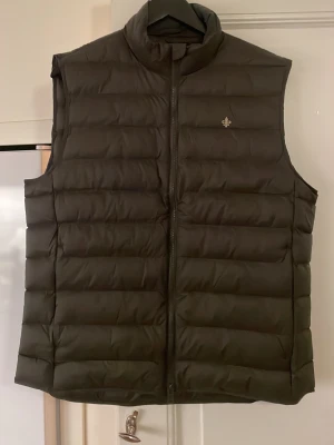 Morris Mörkgrön dunväst - Snygg mörkgrön dunväst med quiltad design och ståkrage. Aldrig använd, etiketten sitter kvar, kvitto finns. Storlek M. Orginalpris: 2299kr Mitt pris: 1900kr