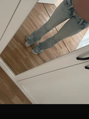 Ljusblå bootcut jeans - Säljer ett par ljusblå bootcut jeans med hög midja och klassiska fem fickor. Jeansen har en snygg tvätt och är tillverkade i denim med lite stretch för skön passform. Perfekta för en trendig och avslappnad look.