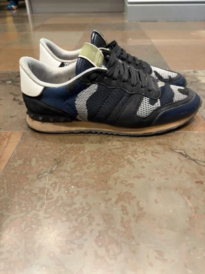 Valentino rockrunners - Snygga valentino rockrunners i blått, svart, vitt och grått. Skorna har svarta mockadetaljer, meshpaneler och vita detaljer vid hälen. Storlek 42 och 8,5/10 skick.