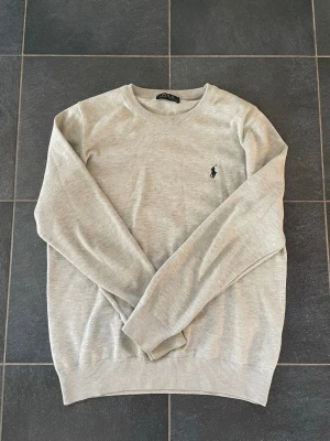 Ljusgrå tröja från Ralph Lauren -  Ljusgrå crewneck från Ralph Lauren i riktigt bra skick med klassisk rund halsringning och den ikoniska mörkblå polospelaren broderad på bröstet. Storlek M.  Tröjan har ribbade muddar vid ärmslut och nederkant, perfekt för våren! Skriv vid funderingar:)
