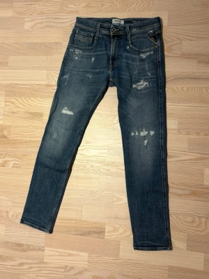 Replay Jeans - Säljer ett par blå jeans från Replay med slitna detaljer framtill. Sparsamt använda och bra skick. Nypris 2000 men säljer för endast 649