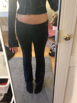 Mörkblått stickat set med croppad tröja - Säljer ett stickat set med croppad långärmad tröja och matchande byxor med utsvängda ben. Setet är mjukt och stretchigt, perfekt för dig som gillar yogapants! St 170/S. Säljer pga dom bara ligger i min garderob💕