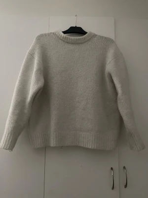 Vit stickad tröja från Zara - En varm och rätt så grov och tjock stickad tröja ifrån Zara . Tröjan är i rätt bra skick och inga defekter. (Färgen är bättre egentligen men bara ljuset som gör att den inte ser helt vit ut men den är de). Tröjan är rätt så stor i storleken skulle jag säga.